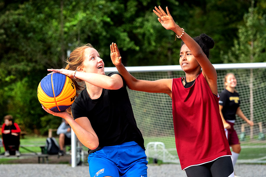 Två flickor spelar basket i Larsbergsparken.