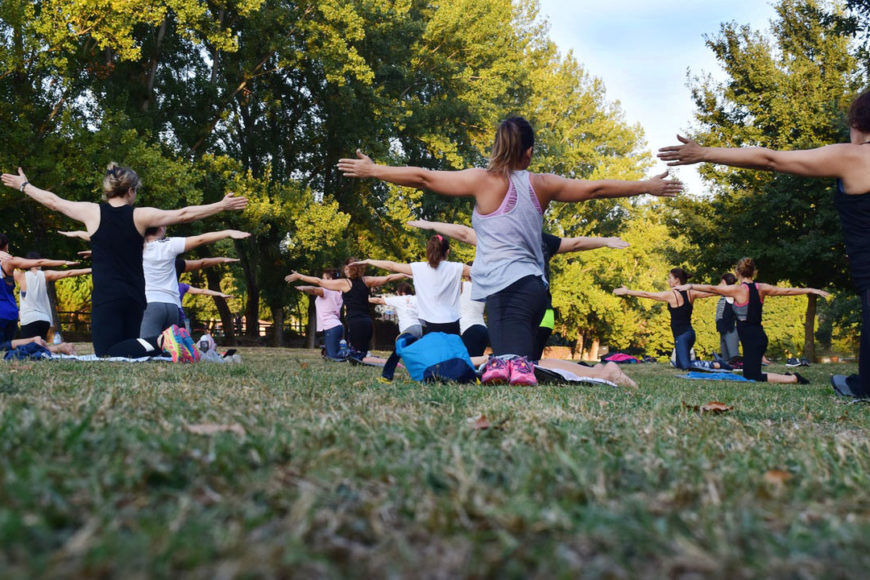 Kvinnor tränar yoga i park.